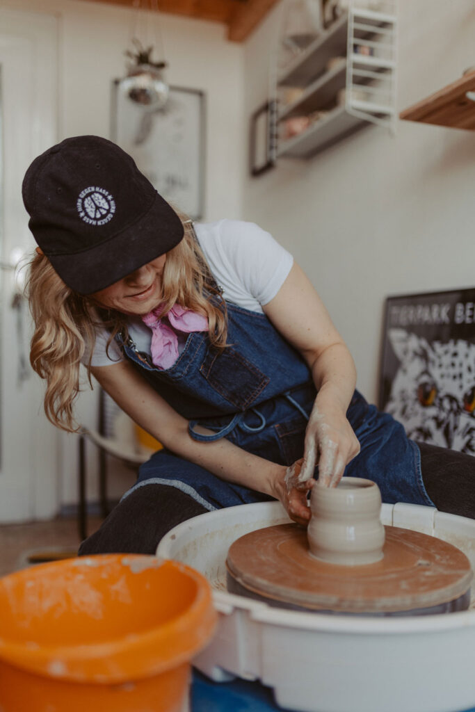 eine Töpferin in berlin lässt sich fotografieren und sie töpfert an der Drehscheibe Tassen und Vasen. ihr Atelier ist im Funkhaus in berlin und sie hat mich beauftragt ihre Business fotos zu machen.