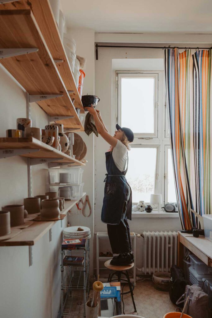 eine Töpferin in berlin lässt sich fotografieren und sie töpfert an der Drehscheibe Tassen und Vasen. ihr Atelier ist im Funkhaus in berlin und sie hat mich beauftragt ihre Business fotos zu machen.