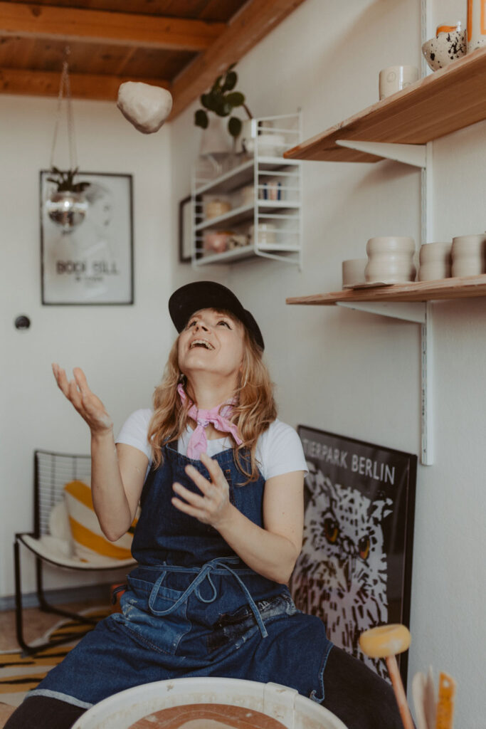 eine Töpferin in berlin lässt sich fotografieren und sie töpfert an der Drehscheibe Tassen und Vasen. ihr Atelier ist im Funkhaus in berlin und sie hat mich beauftragt ihre Business fotos zu machen.