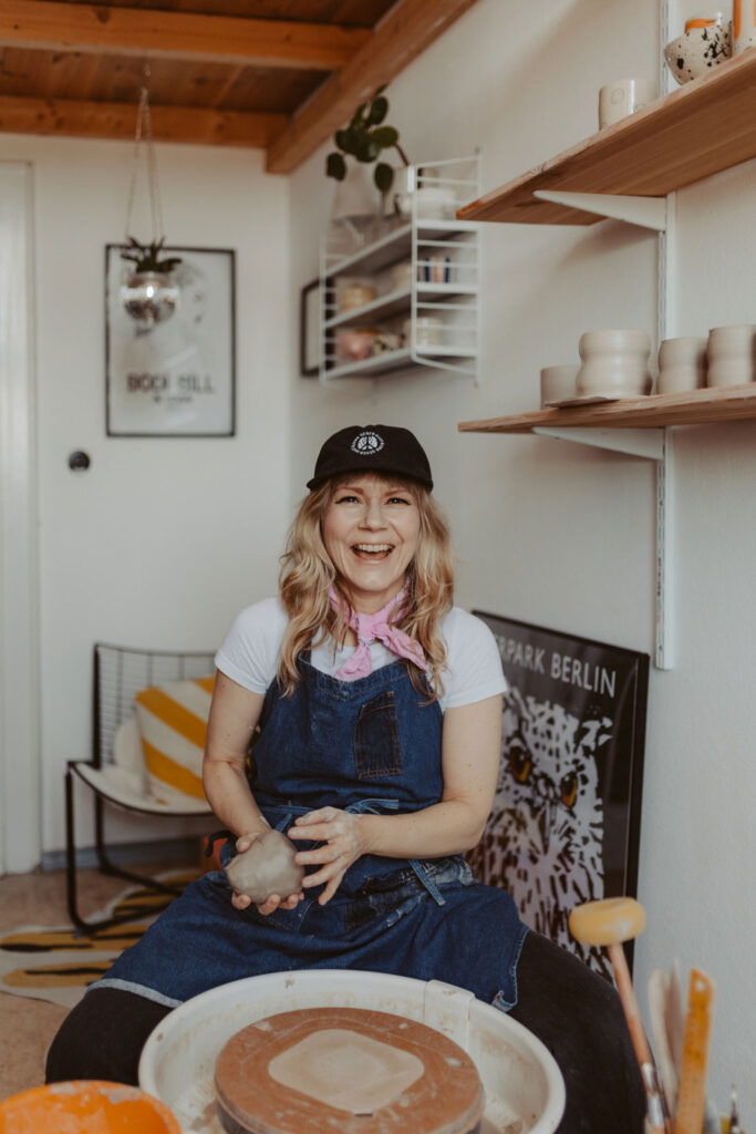 eine Töpferin in berlin lässt sich fotografieren und sie töpfert an der Drehscheibe Tassen und Vasen. ihr Atelier ist im Funkhaus in berlin und sie hat mich beauftragt ihre Business fotos zu machen.