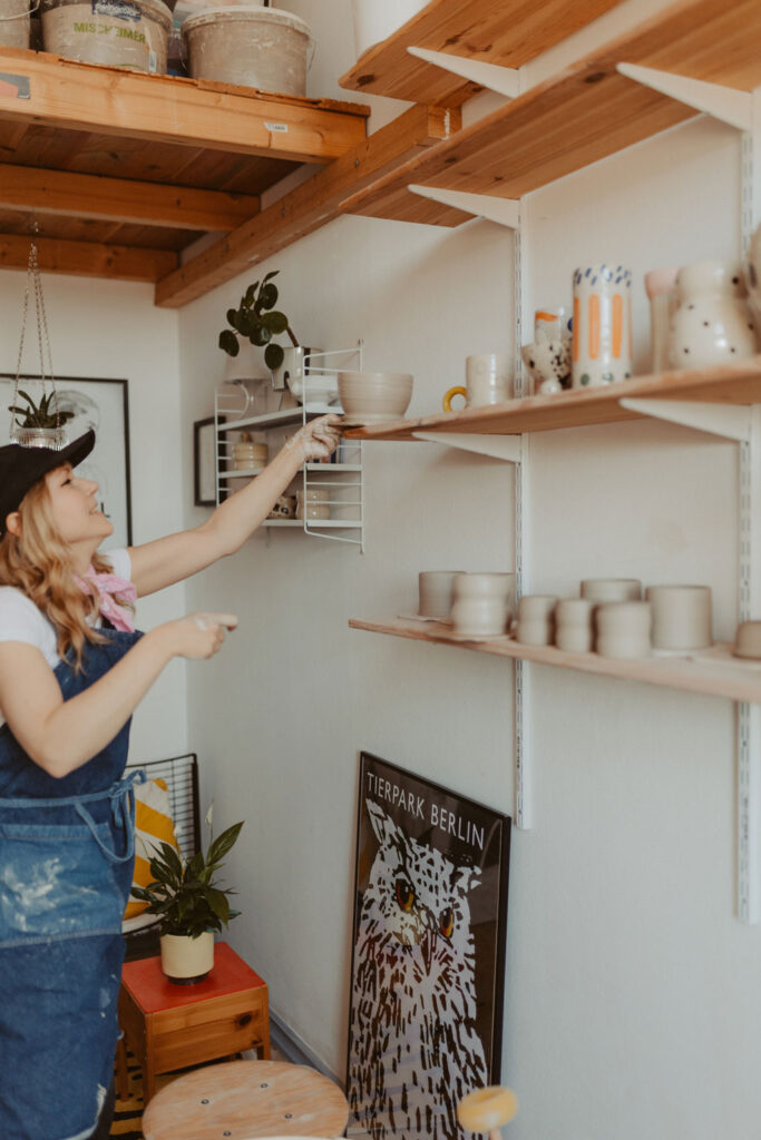 eine Töpferin in berlin lässt sich fotografieren und sie töpfert an der Drehscheibe Tassen und Vasen. ihr Atelier ist im Funkhaus in berlin und sie hat mich beauftragt ihre Business fotos zu machen.