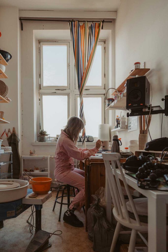 eine Töpferin in berlin lässt sich fotografieren und sie töpfert an der Drehscheibe Tassen und Vasen. ihr Atelier ist im Funkhaus in berlin und sie hat mich beauftragt ihre Business fotos zu machen.