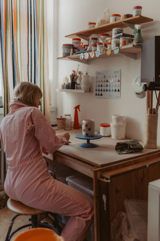 eine Töpferin in berlin lässt sich fotografieren und sie töpfert an der Drehscheibe Tassen und Vasen. ihr Atelier ist im Funkhaus in berlin und sie hat mich beauftragt ihre Business fotos zu machen.