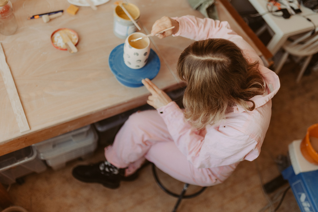 eine Töpferin in berlin lässt sich fotografieren und sie töpfert an der Drehscheibe Tassen und Vasen. ihr Atelier ist im Funkhaus in berlin und sie hat mich beauftragt ihre Business fotos zu machen.